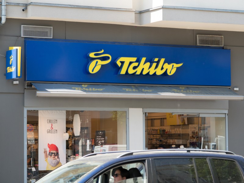 Tchibo Logo an einem Shop- Eingang in der Stadt.