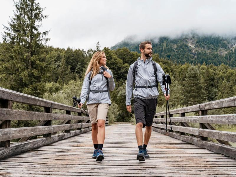 Mann und Frau gehen gerade auf einer Br&uuml;cke beim Wandern.