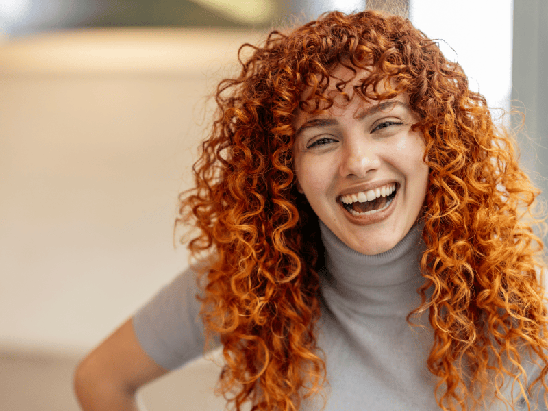 Frau mit lockigen, roten Haaren