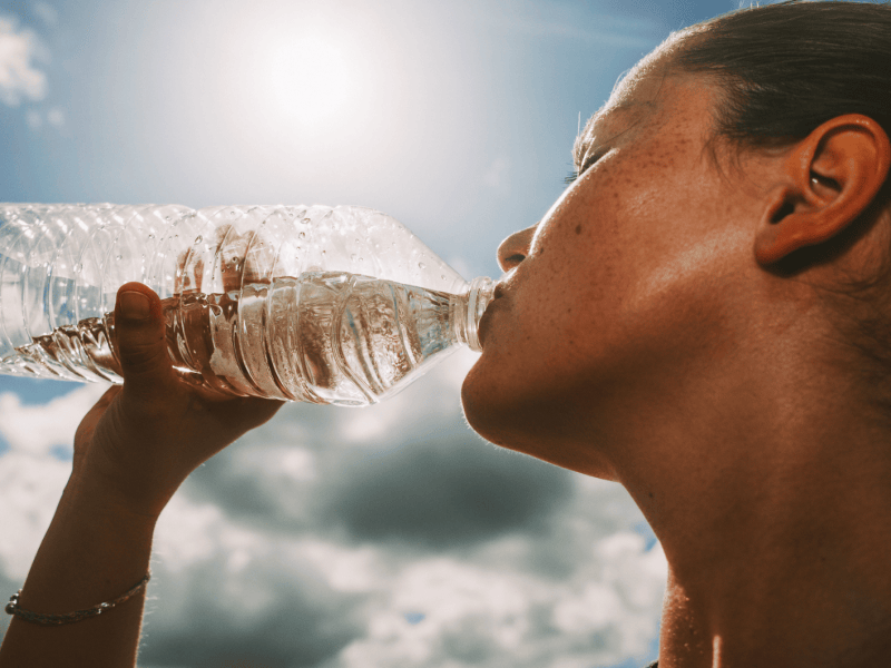 Frau trinkt aus Wasserflasche.