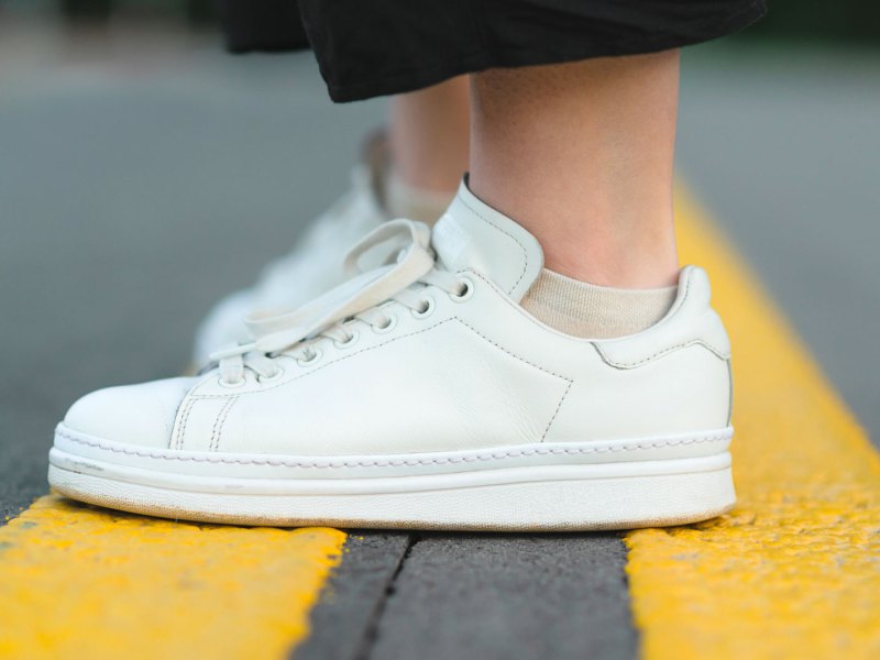 Frauenbeine mit wei&szlig;en Sneaker als Bild f&uuml;r Schwei&szlig;f&uuml;&szlig;e in Sneakers