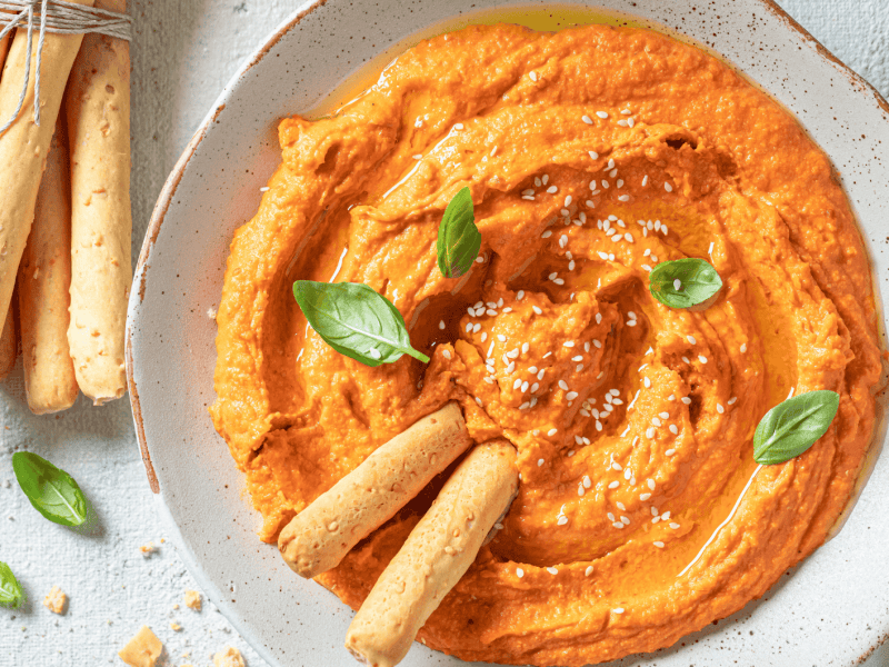 Cremiger Tomate-Mozzarella-Dip in einer wei&szlig;en Schale.