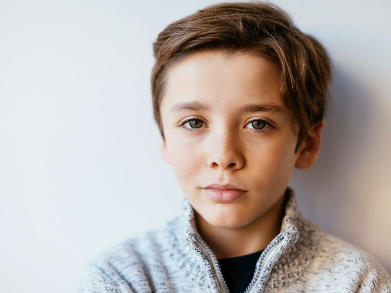 Potr&auml;t eines Jungen, ca. 10 Jahre alt, der skeptisch in die Kamera schaut.