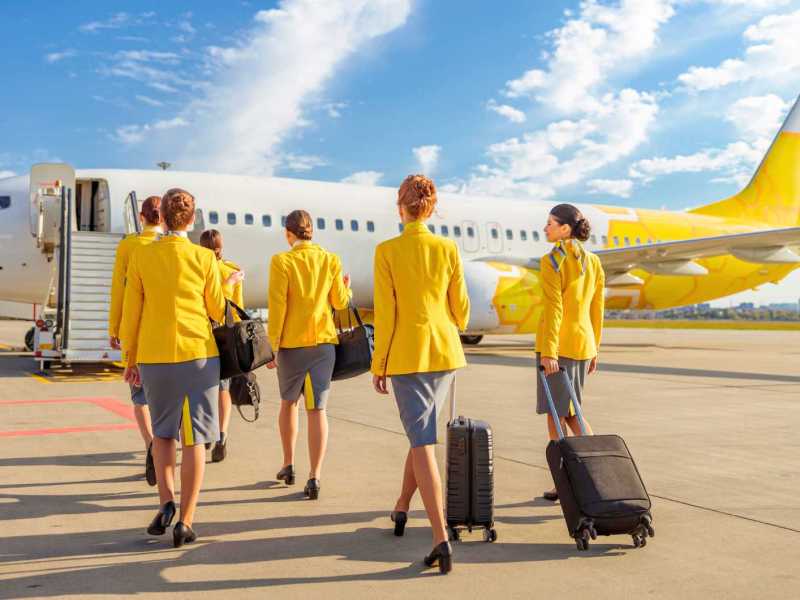 Flugbegleiterinnen auf dem Weg zum Flugzeug.