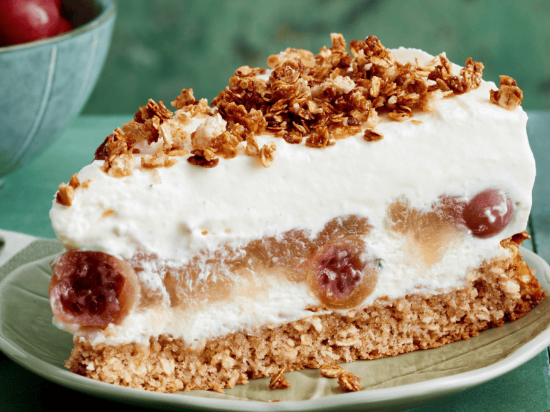 St&uuml;ck Stachelbeertorte auf einem gr&uuml;ner Kuchenteller.