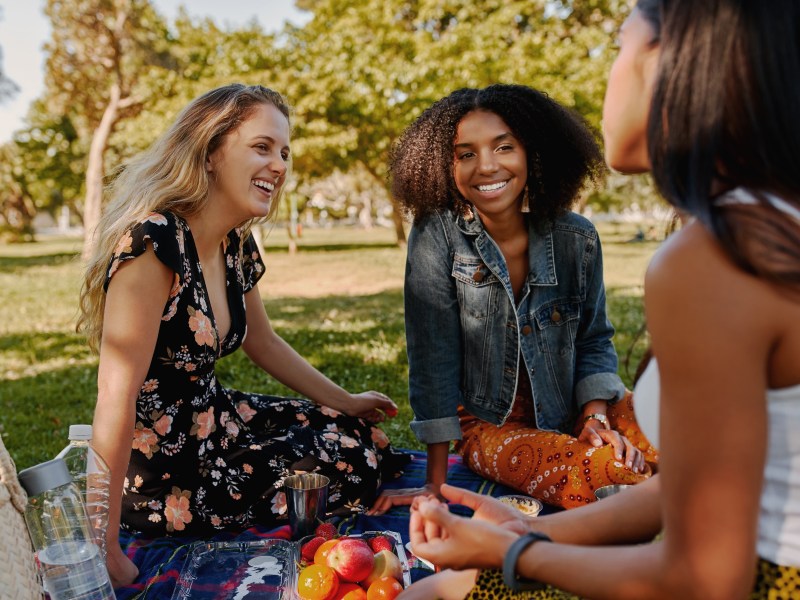 drei Frauen sitzen bei einem Picknick im Grünen