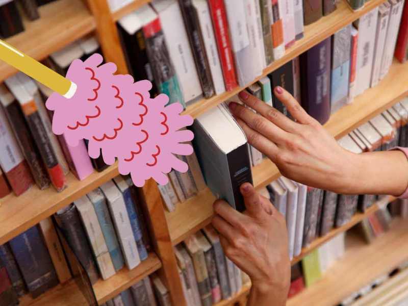 Frau nimmt Buch aus Bücherregal
