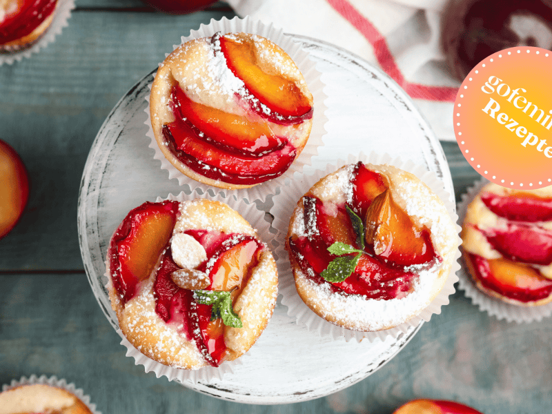 Leckere s&uuml;&szlig;e Cupcakes mit Pflaumen auf Holzst&auml;nder