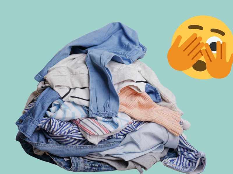 Wäscheberg mit Kleidung und Smiley, das sich die Augen zuhält