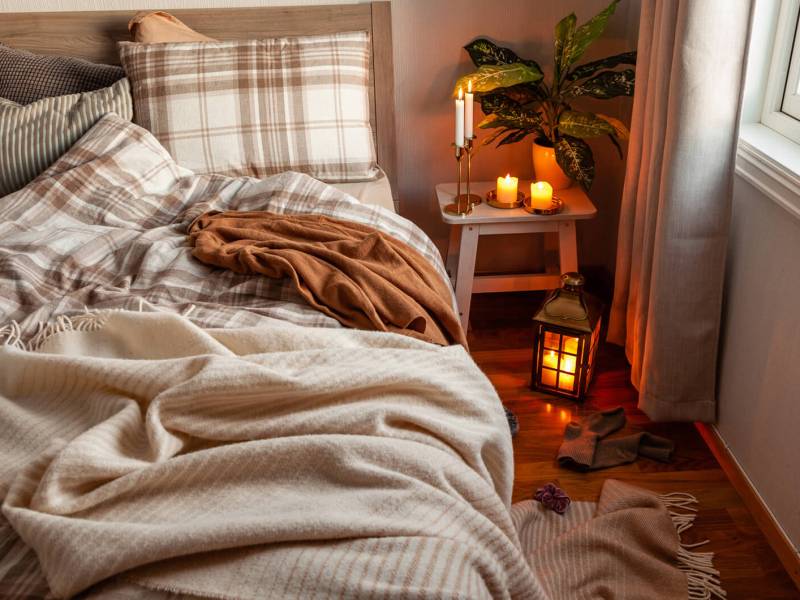 Gem&uuml;tliches Herbst-Schlafzimmer mit Kerzen und Kuscheldecken