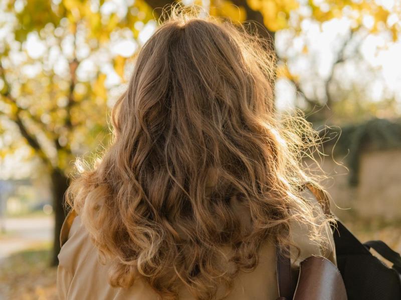 Leicht gewellte und lockige Haare einer Frau von hinten.