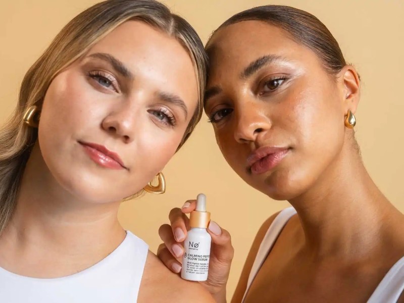 Caroline R. Kroll und eine Frau halten ein neues Serum in der Hand