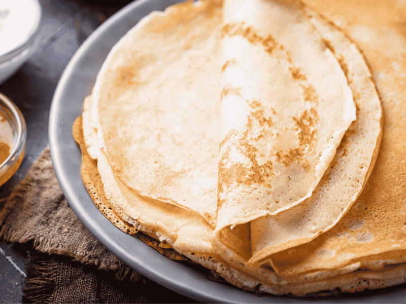 Ein Stapel mit Crepes auf einem grauen Teller.