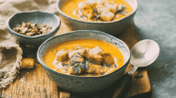 K&uuml;rbissuppe in grauen Sch&auml;lchen.