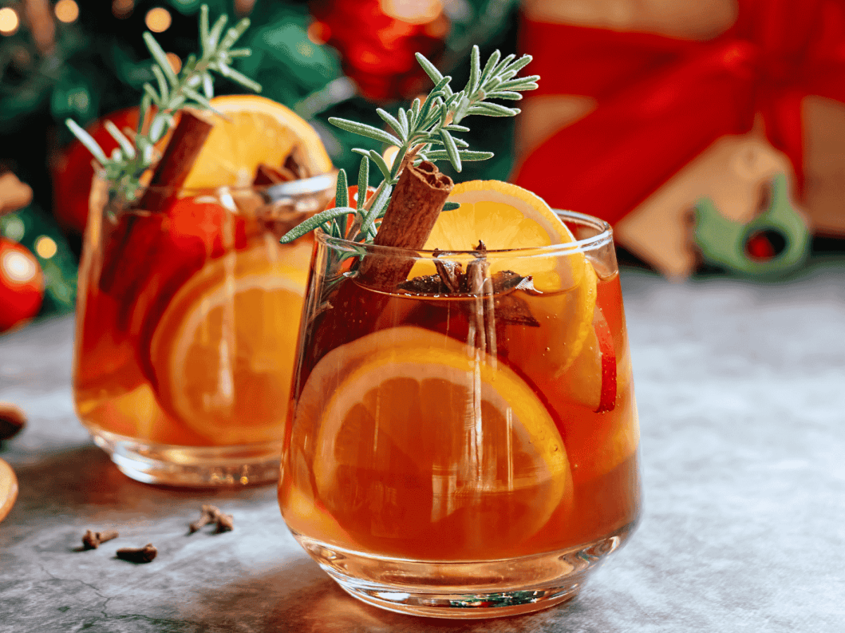 Winterliche Sangria mit Zimtstangen, Orangen und Rosmarin.