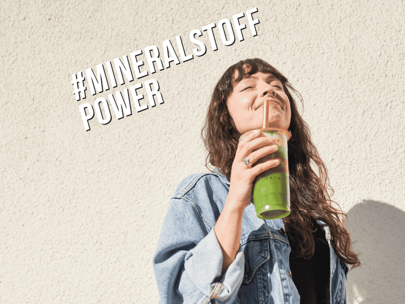 Frau mit grünem Smoothie als Symbol für Achtsamkeit und ein funktionierendes Immunsystem.