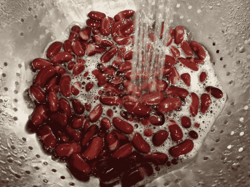 Kidneybohnen in Sieb werden abgespült.