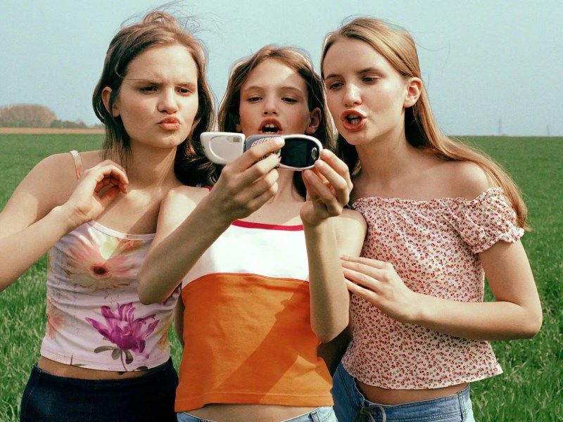 Drei Teenagerm&auml;dchen machen ein Selfie vor einem Feld.