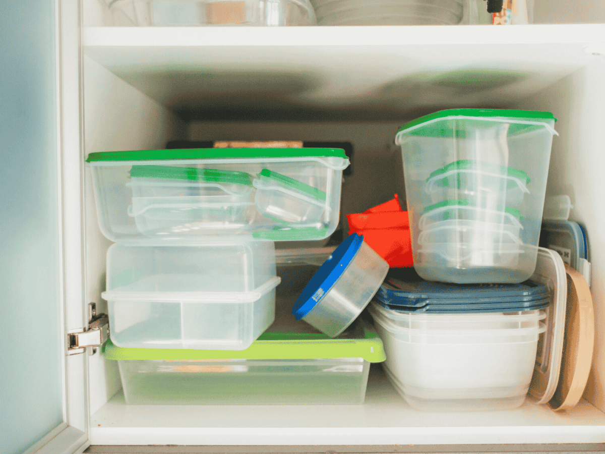 Voller K&uuml;chenschrank mit Plastikbeh&auml;ltern.