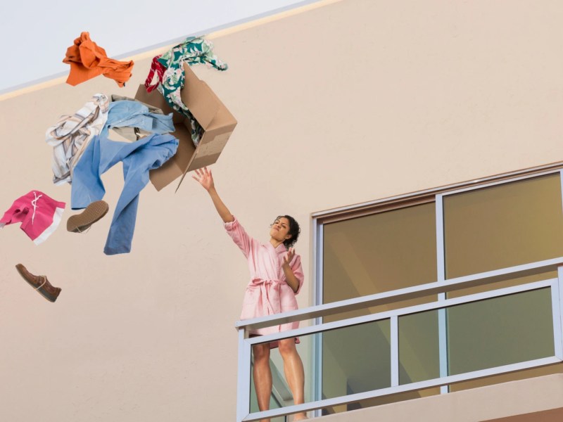 Frau wirft Kleidung vom Balkon