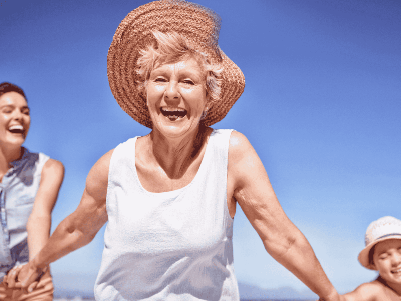Familie mit Großmutter läuft am Strand.