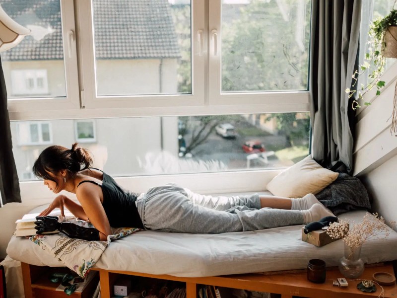Teenagerm&auml;dchen liegt am Tag auf ihrem Bett und liest.