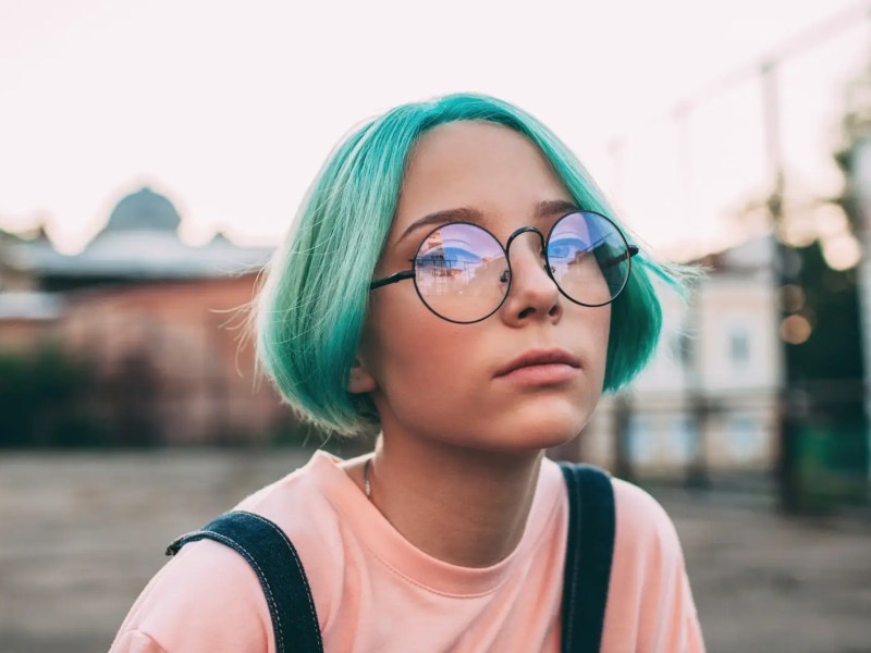 Portr&auml;t eines Teenagerm&auml;dchens mit gr&uuml;nlich-blauen Haaren.