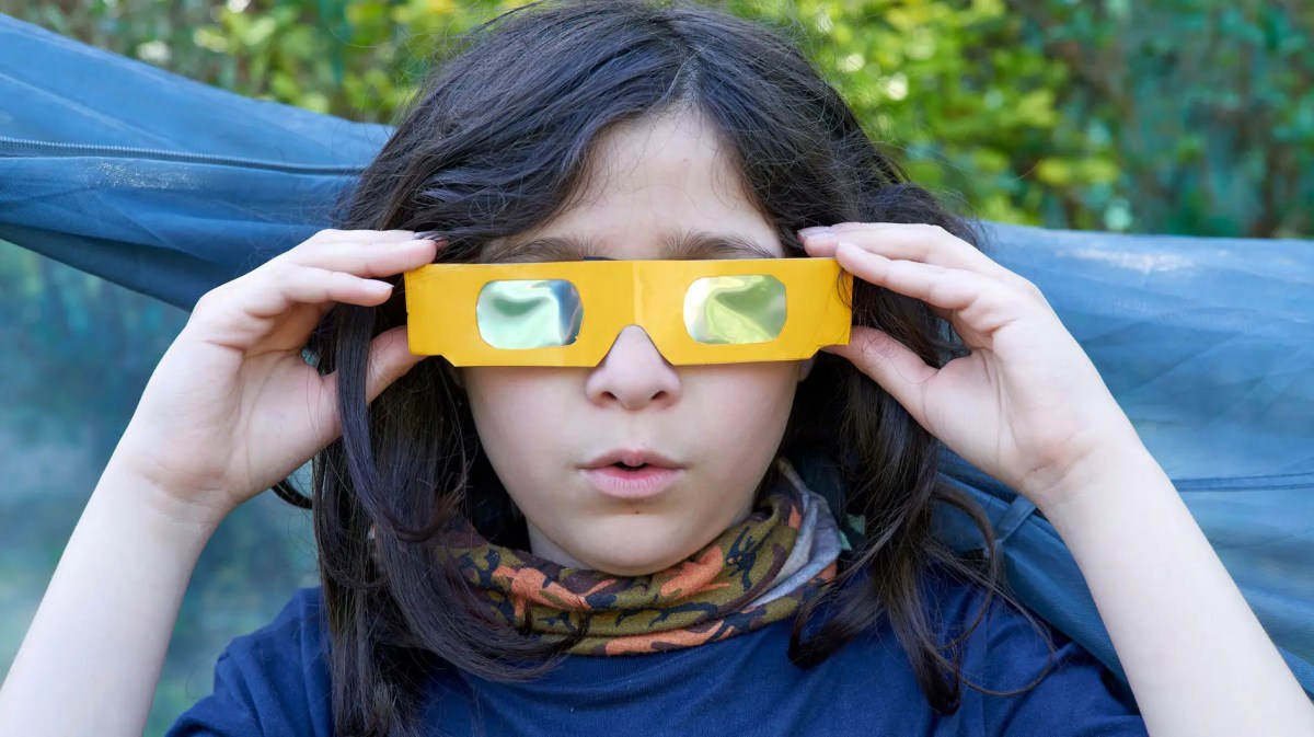 Teenagerjunge mit Sonnenfinsternis-Brille