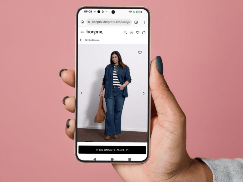 Hand h&auml;lt Handy mit bonprix Onlineshop darauf hoch