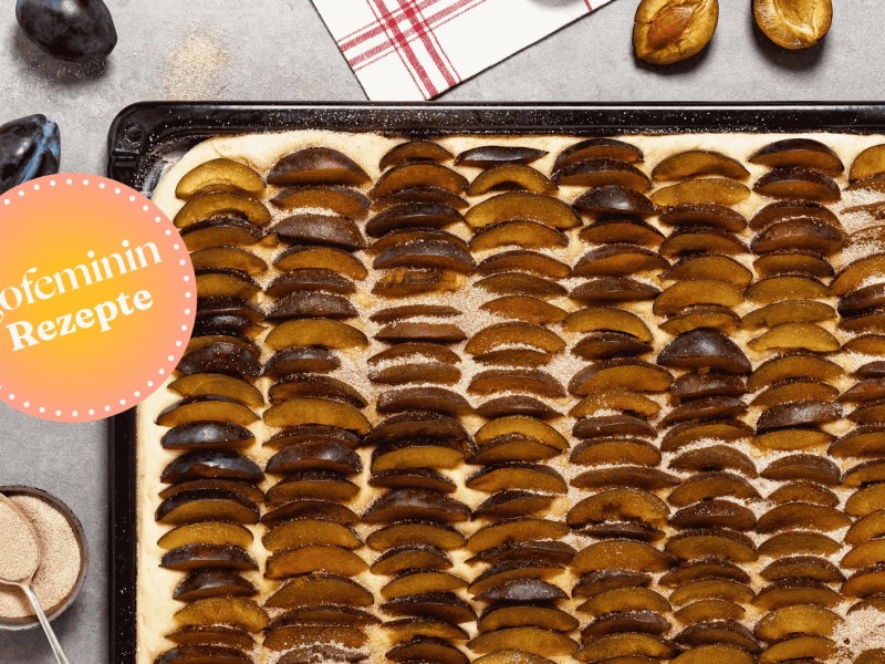 Hausgemachter leckerer Blechkuchen mit frischen Pflaumen und Zimt-Zucker vor dem Backen